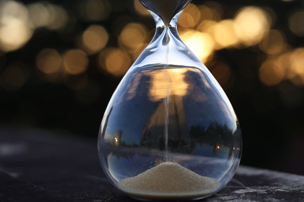 Clock and hourglass showing time running out, a reminder that 1-hour payday loans are never guaranteed to pay out in an hour