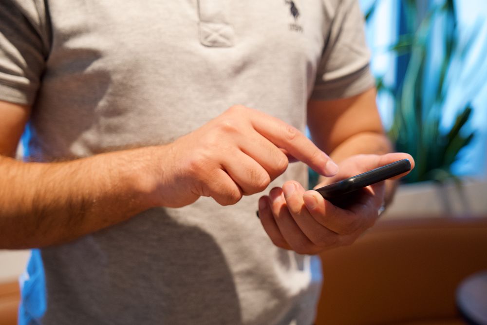Person reading messages on a smartphone, where many 1 hour payday loans no credit check adverts reach you