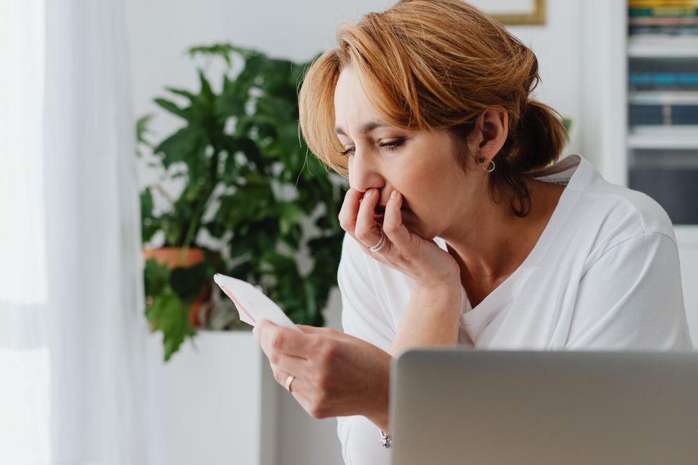 Person going through bills and receipts at a table
