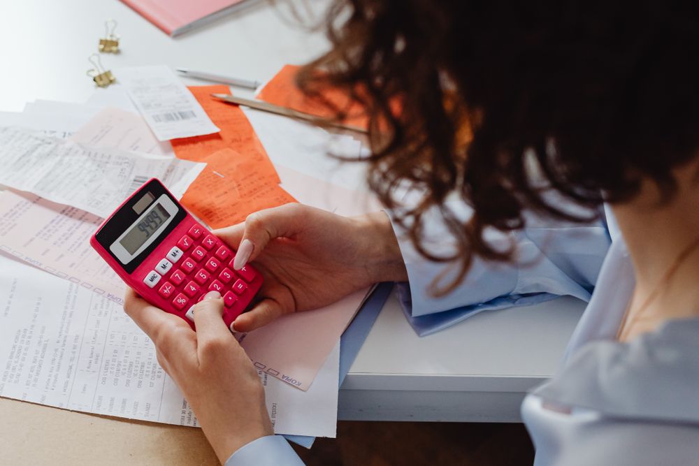 Person using a calculator with papers on a desk, working out what being blacklisted really limits