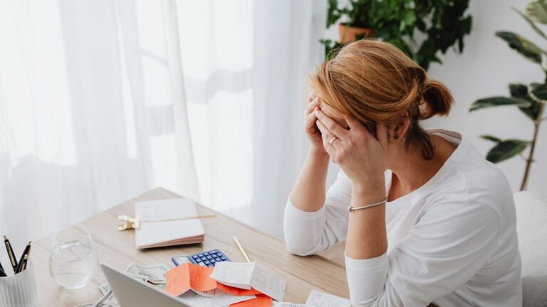 Person with head in hands worried about unpaid debts