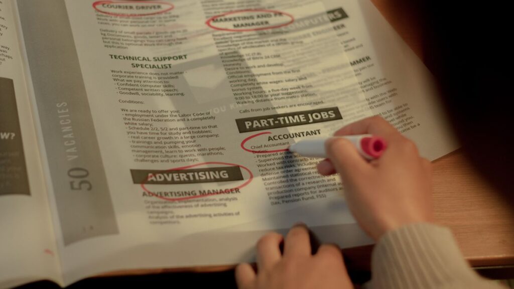 Person searching for work with a CV and job notices