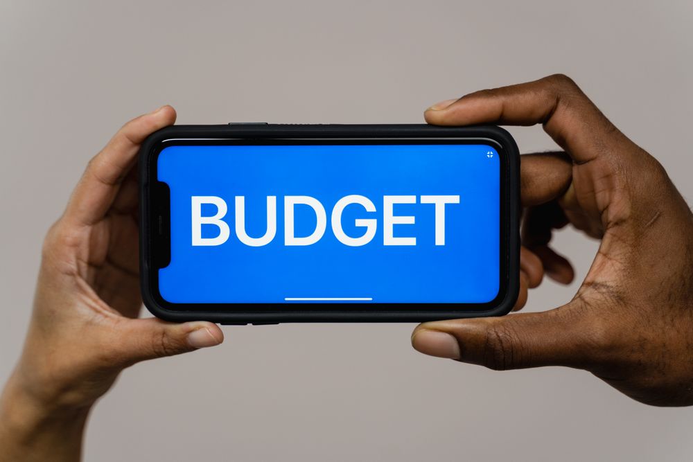 Notebook ledger and phone for tracking a monthly budget