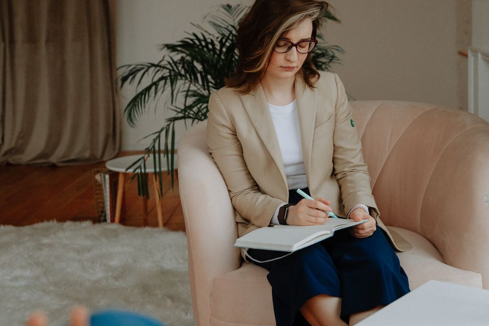 Adviser taking notes while talking with clients, explaining a complaint to the Credit Ombud