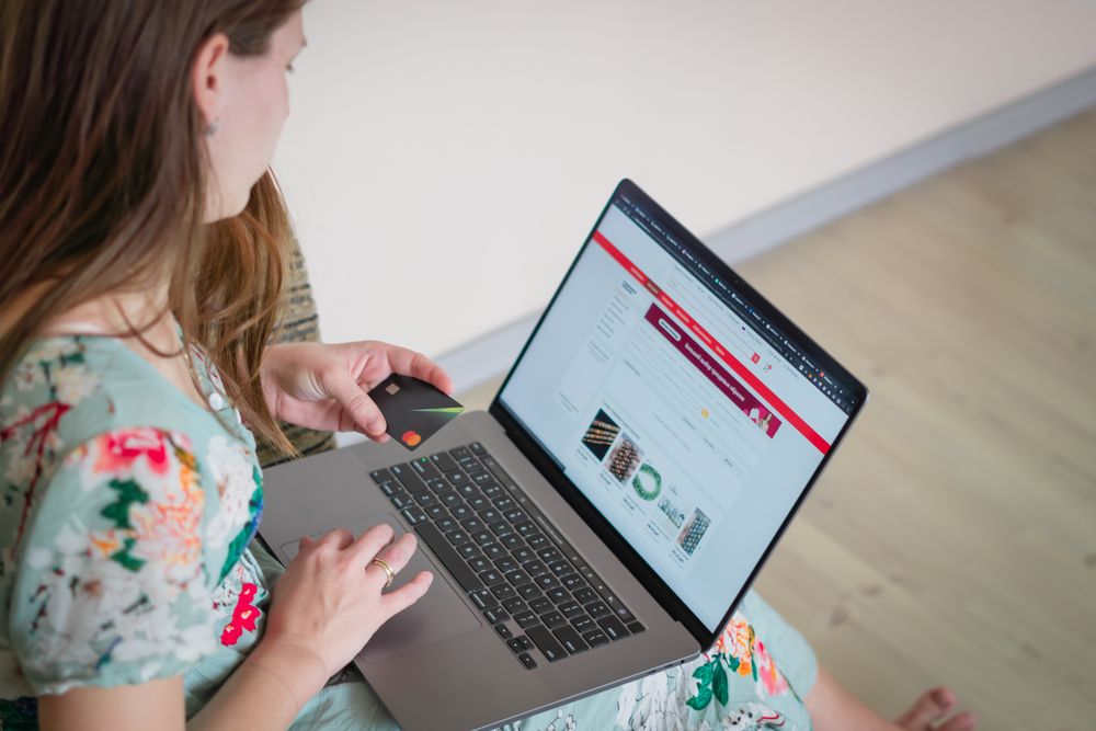 Person paying by card on a laptop