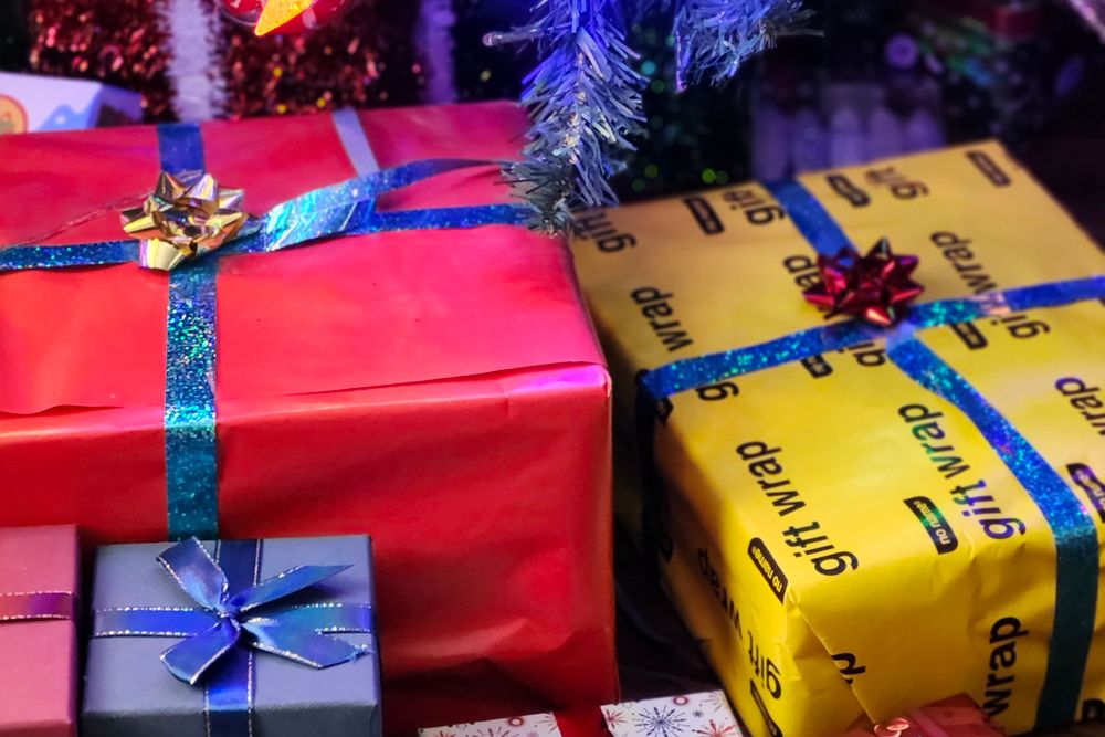 Wrapped Christmas gifts and festive decorations, a family planning a December budget at the table