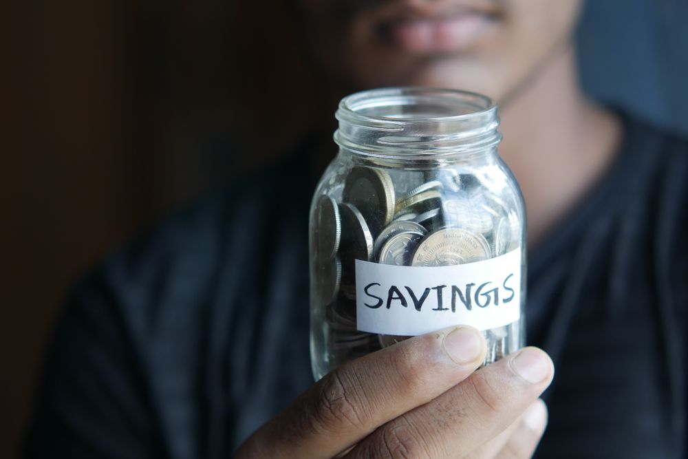 Savings jar with coins, starting an emergency fund with small amounts