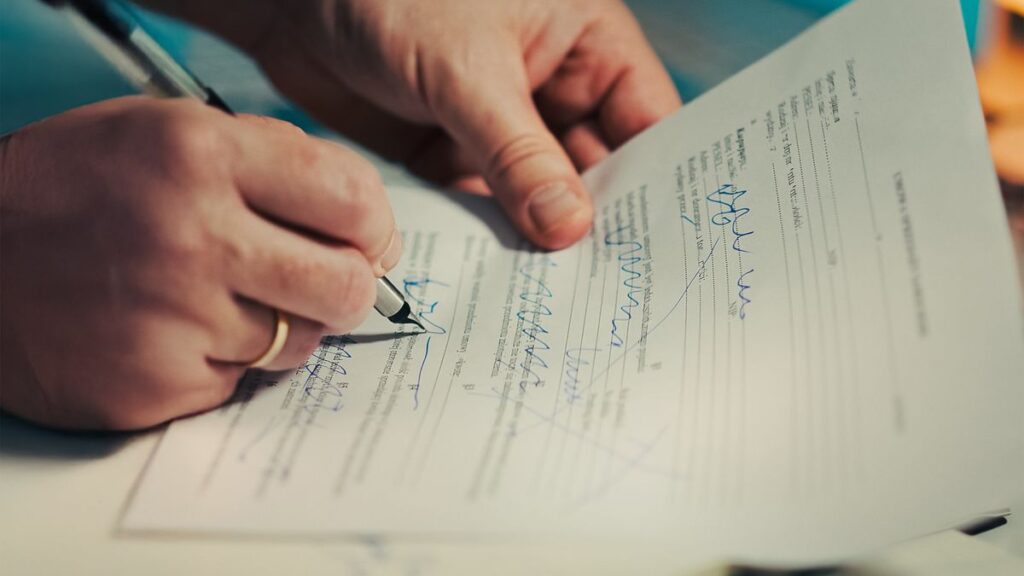 Person reading and signing a credit agreement