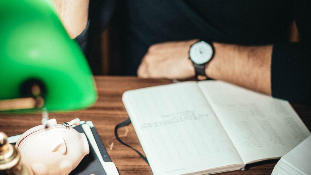 Notebook ledger and phone for tracking a monthly budget