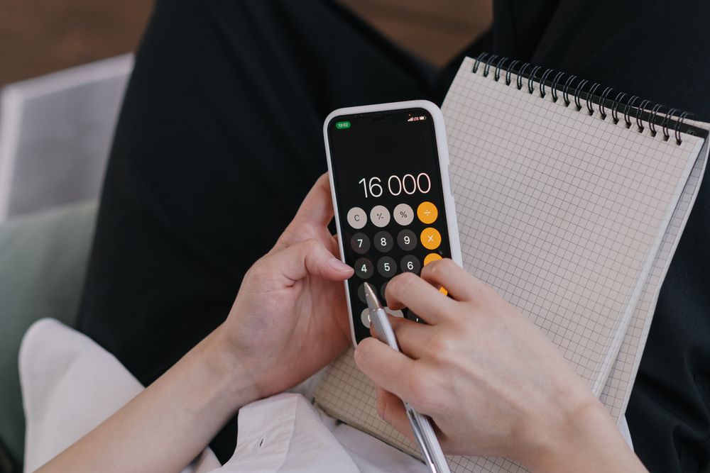 Notebook ledger and phone for tracking a monthly budget