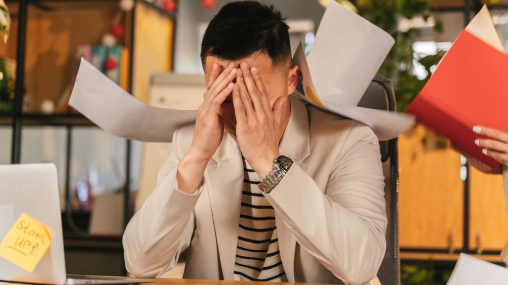 Person worried while going through bills at home