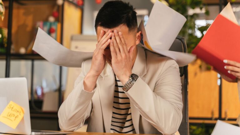 Person worried while going through bills at home