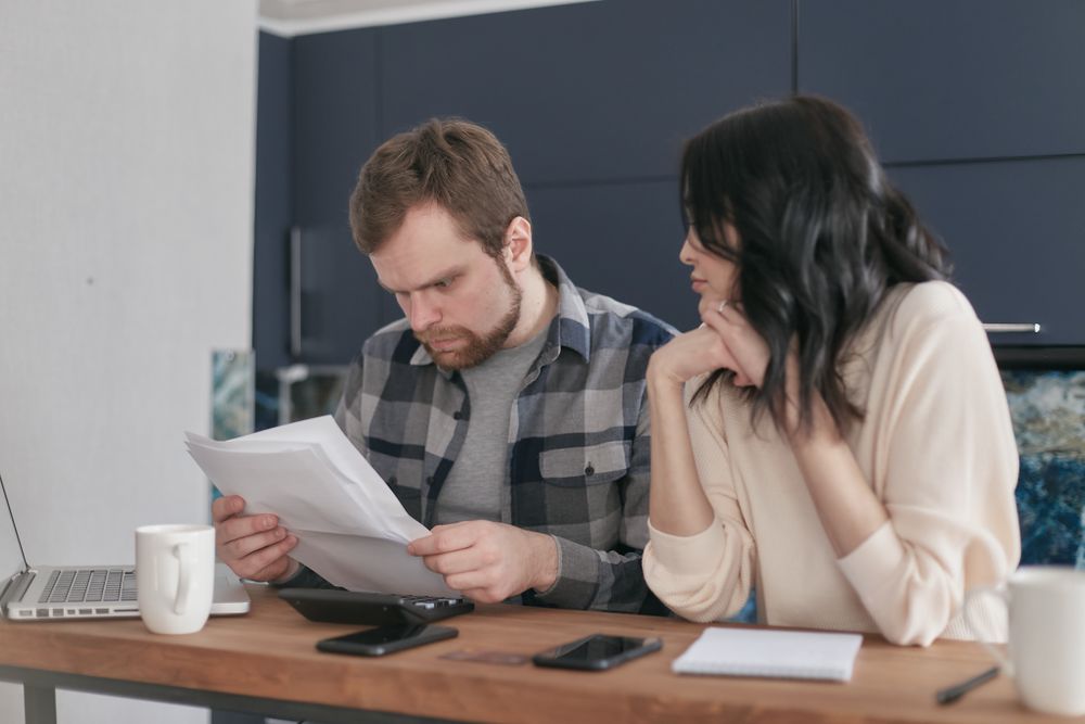Person going through bills and receipts at a table