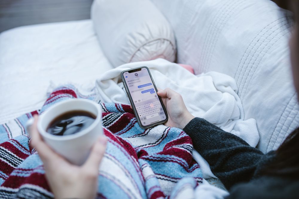 Person reading messages on a smartphone, checking what a loan app asks to access
