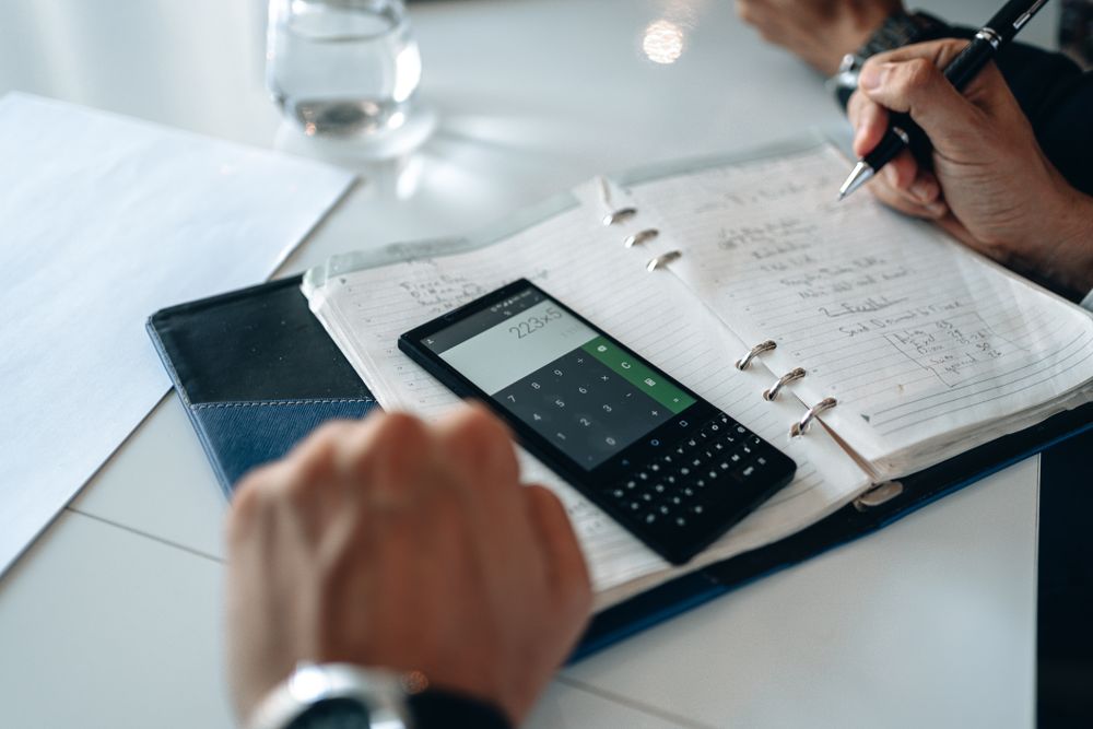 Person using a calculator with papers on a desk