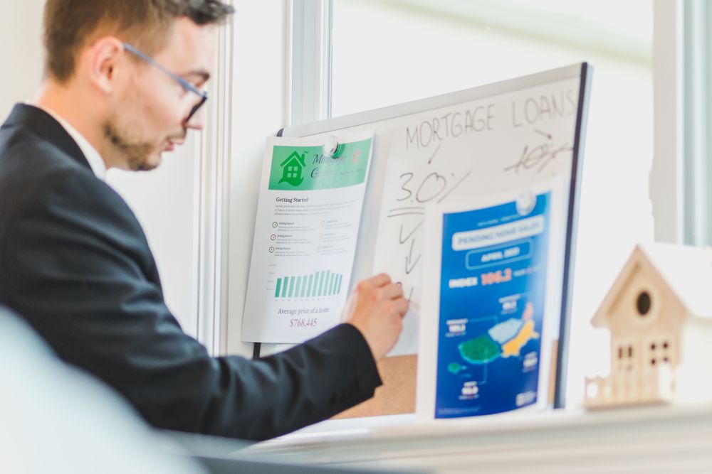 Loan paperwork being reviewed with an adviser, doing a mid-year money check with a calculator and notebook