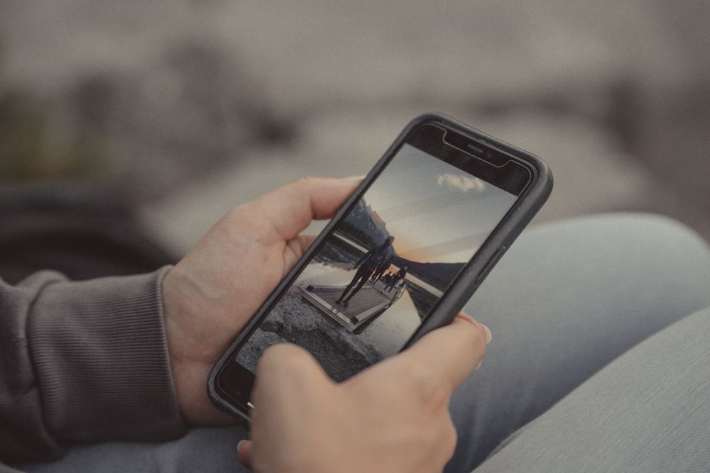 Hand holding a smartphone to make a payment, the way most mini loans are applied for and repaid