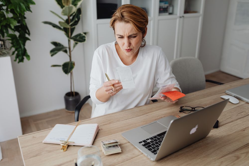 Person going through bills and receipts at a table