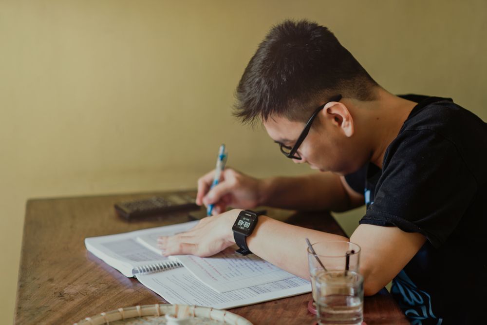 Young people studying with laptops and books, money tips for a young person with a first salary