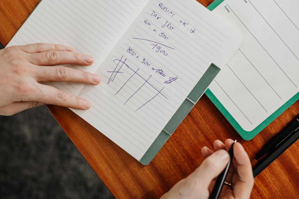 Notebook ledger and phone for tracking a monthly budget