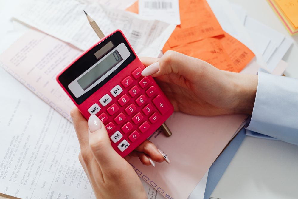 Notebook, calculator and papers on a desk during monthly budget planning