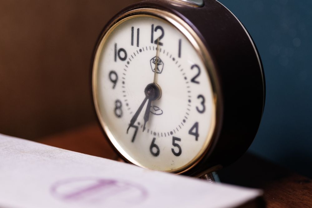Clock and hourglass showing time running out — a reminder that online payday loans are not always paid out within an hour