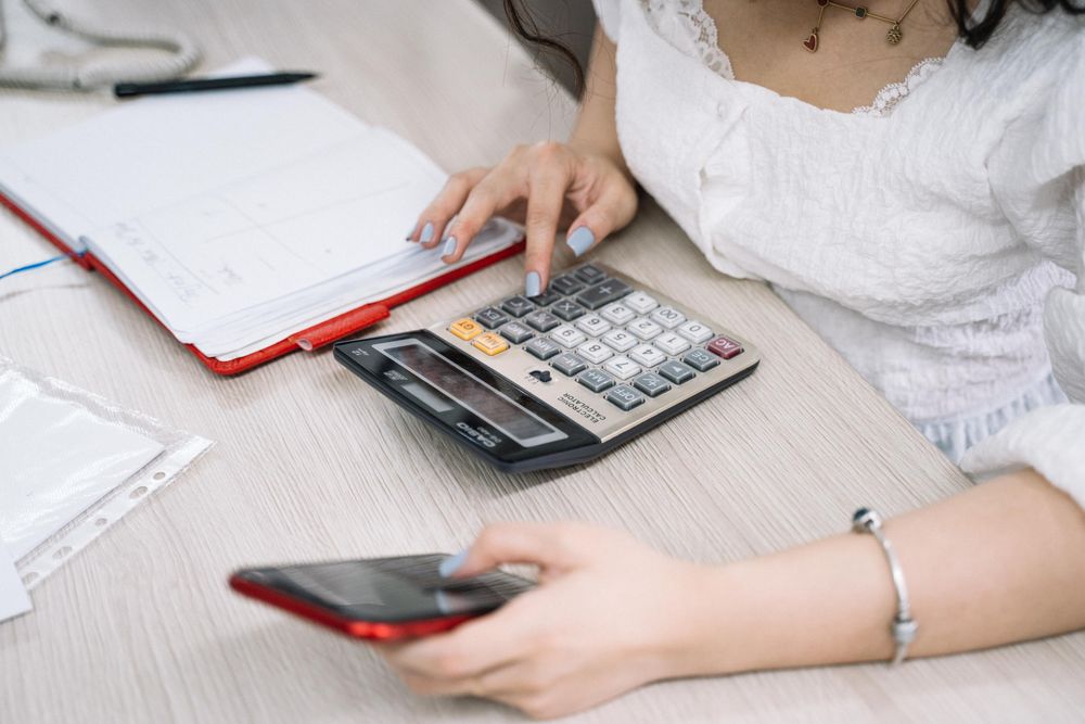 Person using a calculator with papers on a desk