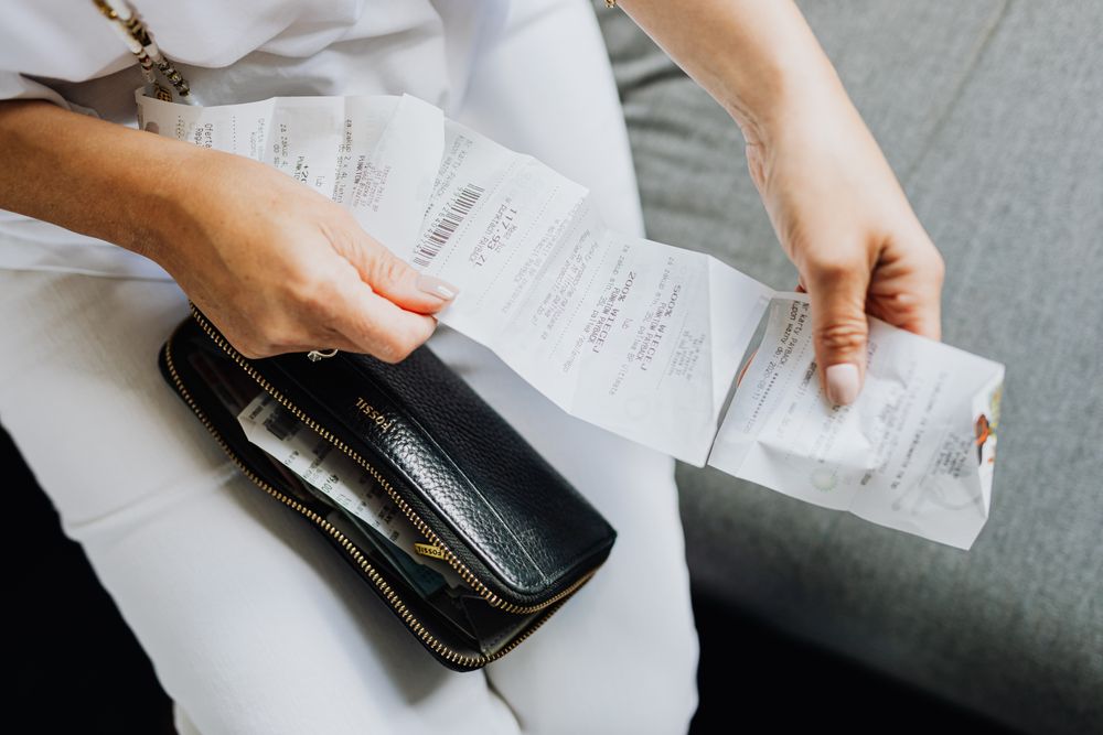 Calculator and household bills laid out on a table, used to plan repayments on payday loans with bad credit