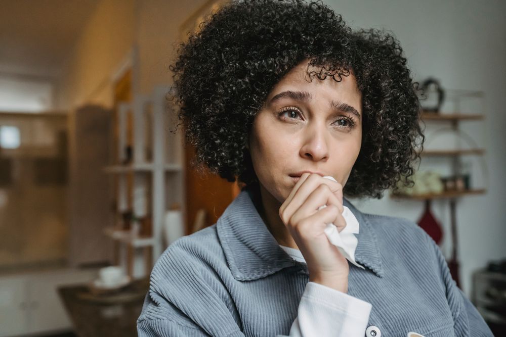 Stressed person with their head in their hands, facing an emergency while under debt review