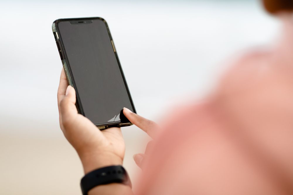 Person using a smartphone at a table, sending an instant PayShap payment