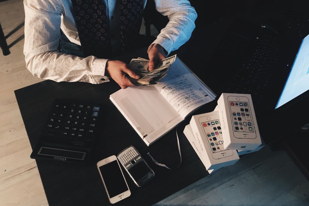 Notebook, calculator and papers on a desk during monthly budget planning for a personal loan for vacation