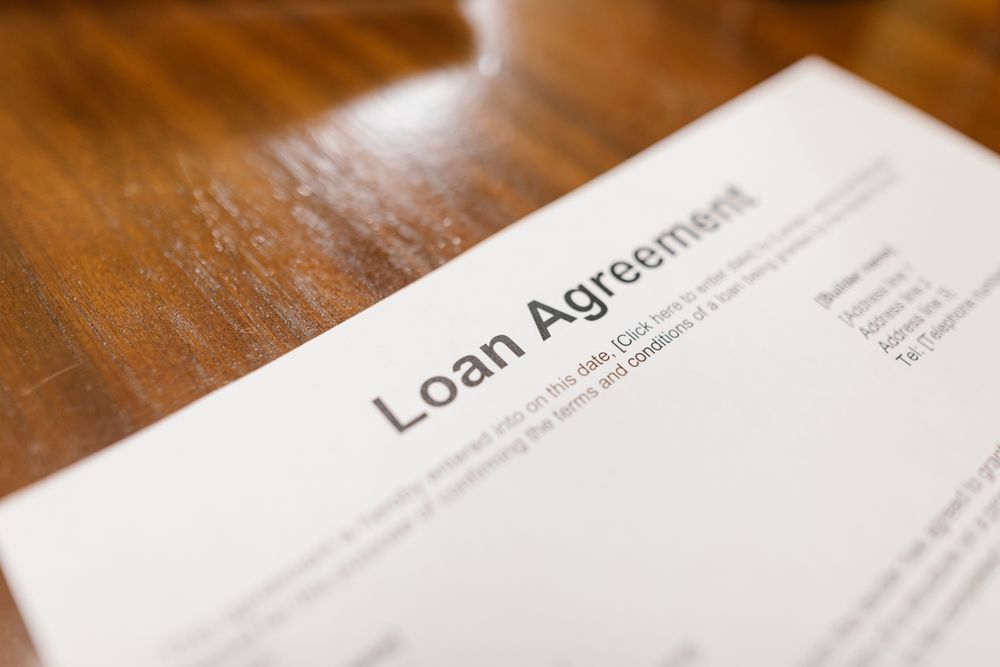 Loan paperwork being reviewed with an adviser, comparing personal loans offers