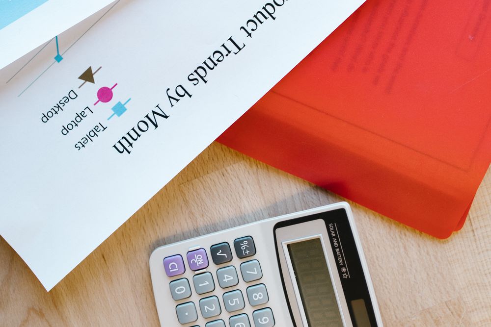 Person using a calculator with papers on a desk