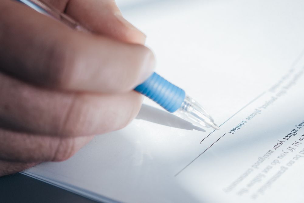 Person signing a contract, reading the pre-agreement quote before you sign