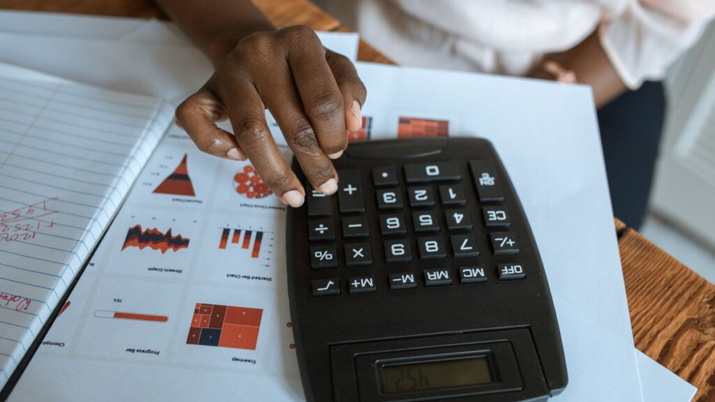 Calculator and papers used to work out what a larger loan costs
