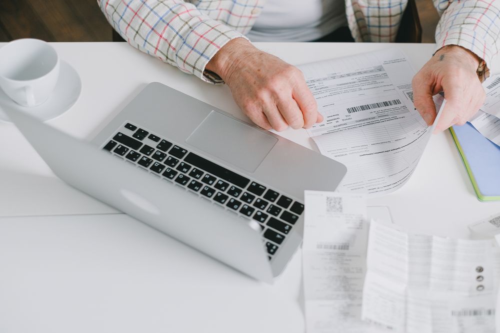 Person going through bills and receipts at a table