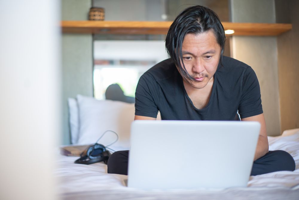 Person working on a laptop at home, checking a registered lender online