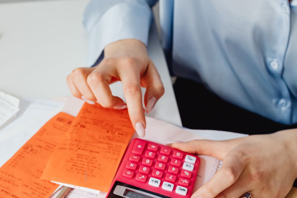 Person using a calculator with papers on a desk