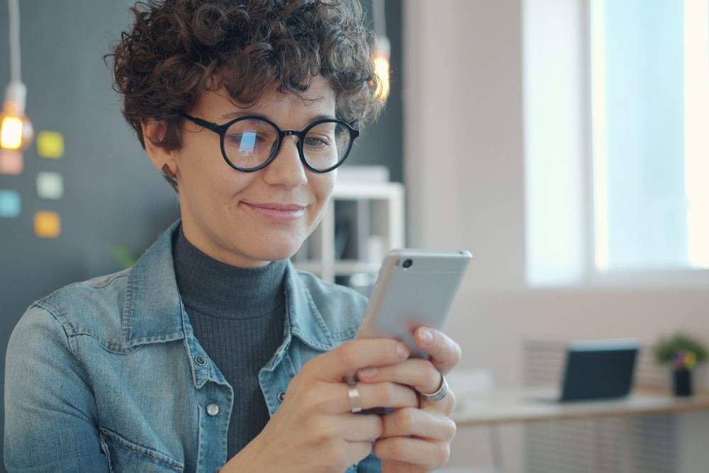 Woman using her smartphone, checking when a same day cash loan will be paid out