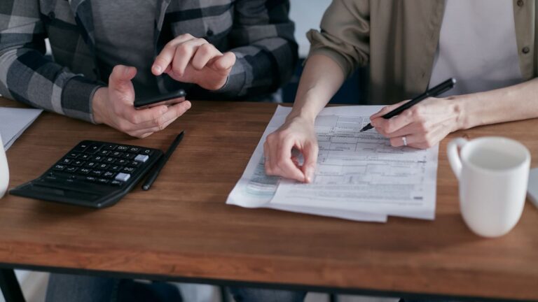 Payslip documents on a desk with a calculator