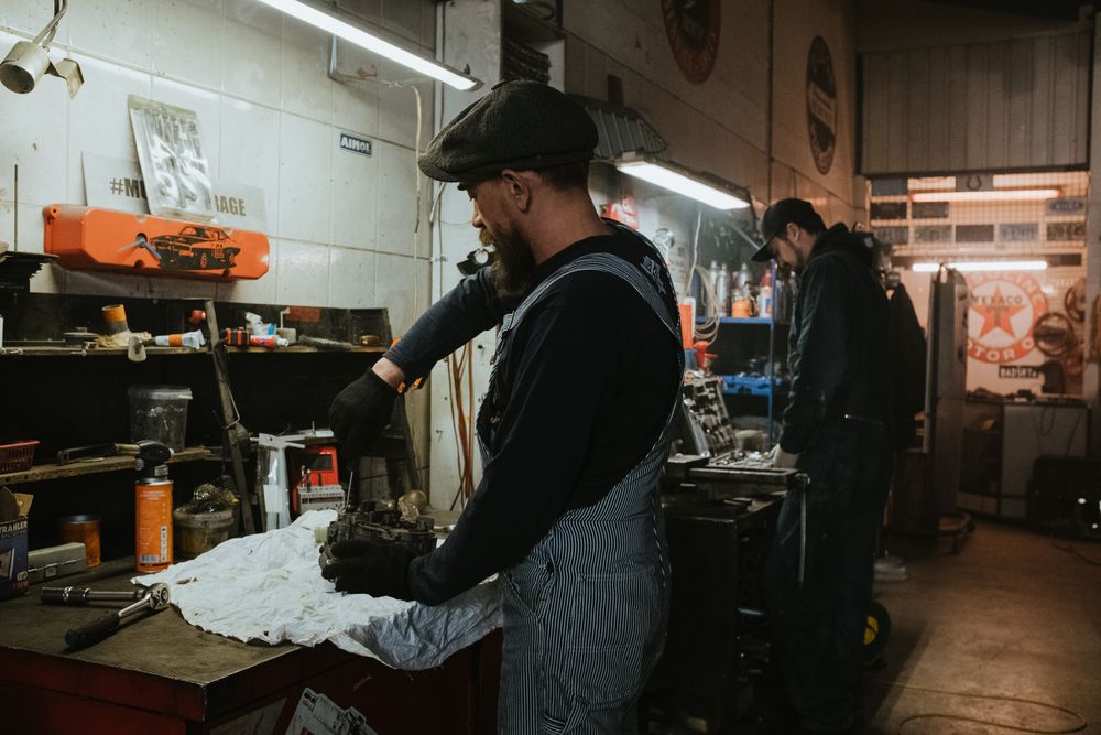 Mechanic repairing a car in a workshop, a driver planning to save for a car