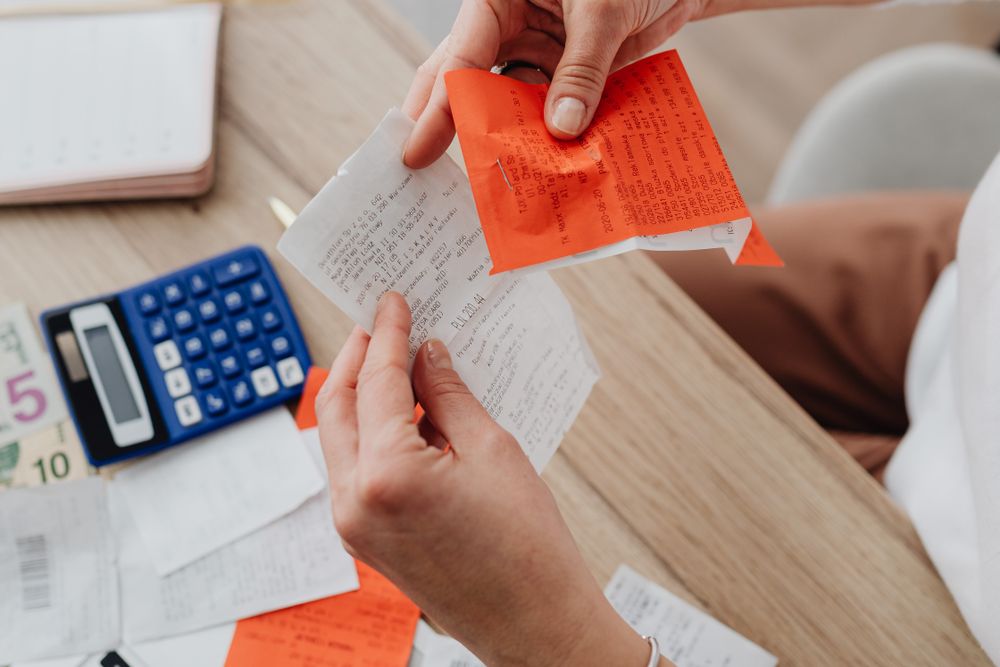 Person going through bills and receipts at a table