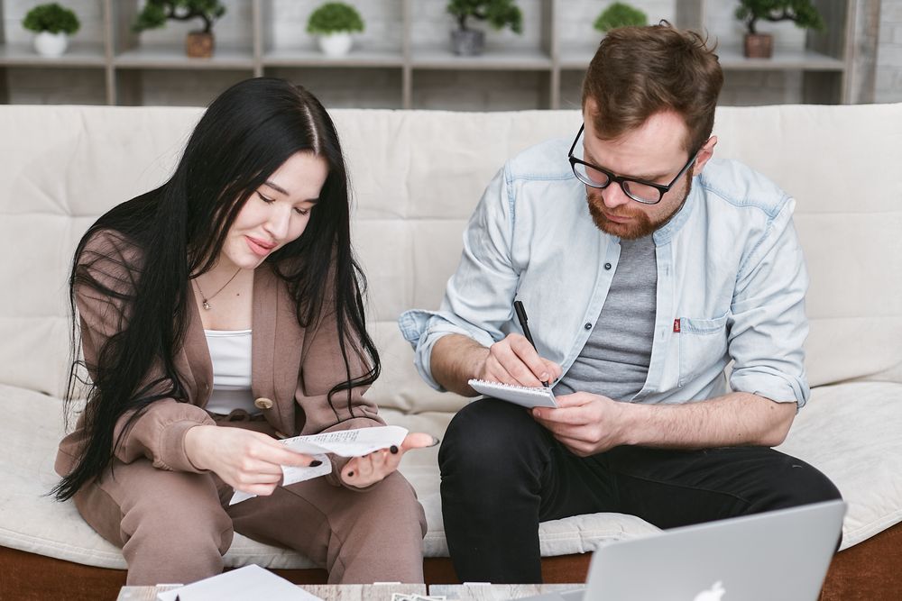 Couple going through household finances at a table, deciding whether to settle a loan early
