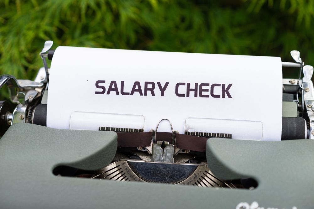 Tax and payslip documents on a desk with a calculator, tax documents to gather as the tax year-end approaches