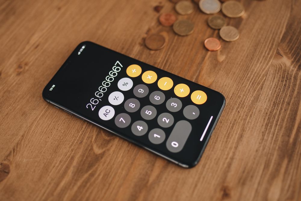 Person using a calculator with papers on a desk