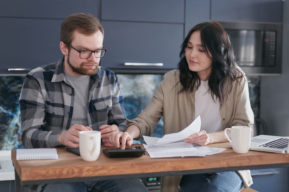 Couple going through household finances at a table