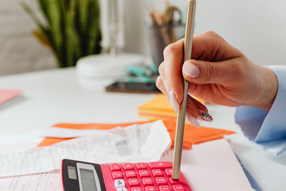 Person using a calculator with papers on a desk